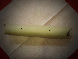 ...mit der Schere Löcher in die Küchenrolle machen ...